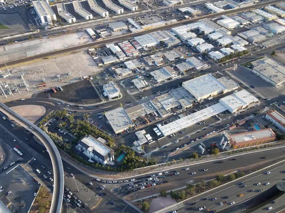 Imagem ampliada de drone de um armazém com cargas e caminhões.